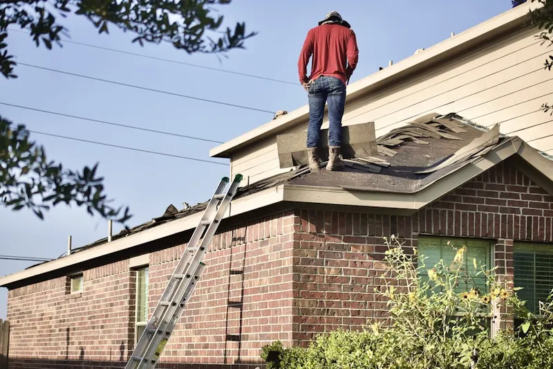 Professional roofer working on a residential roof in Colwyn